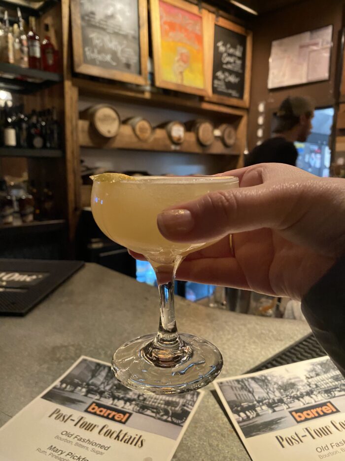 In the foreground, a Bee's Knees cocktail as held by The Hill is Home's María Helena Carey. Barrel (613 Pennsylvania Avenue SE) is the bar in the background